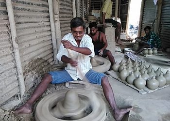 A blind Bappan Paul curving out earthen lamps at his workplace in Srikona