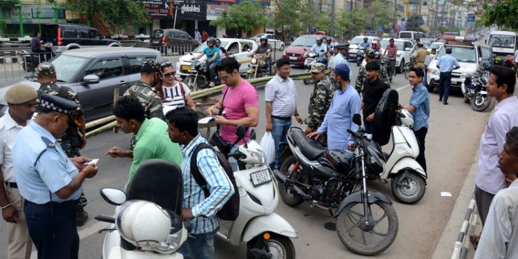 Police personal taking fine for violating traffic rules, at GS Road in Guwahati on Sunday.