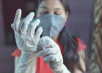 The girl is protecting herself from gloves and stay home. self quarantine. Covid-19 Pandemic.
