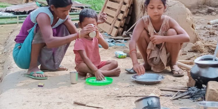 ধুমুহাই উৰুৱাই নিয়া গৃহৰ ভেটিতে মাতৃয়ে এগৰা ভাত খুৱাইছে সন্তানক।