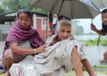 Flood in Assam: হৃদয় বিদাৰক দৃশ্য! কলৰ ভুৰত নদী পাৰ হৈছে অশীতিপৰ আইতাই
