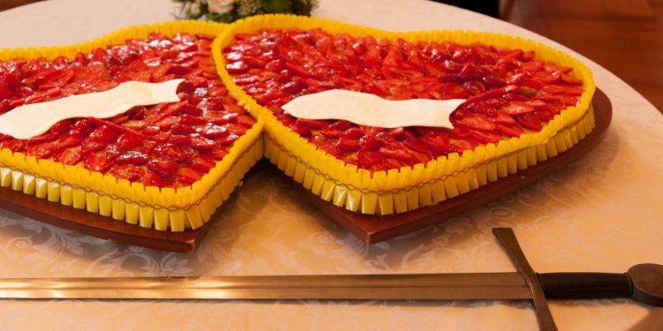 Man Using Sword To Cut Birthday Cake