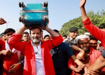 গাত ৰঙা কামিজ, হাতত ‘বেজ’, দিল্লীৰ ৰাজপথত ছুটকেছ লৈ ‘কুলী’ ৰাহুল