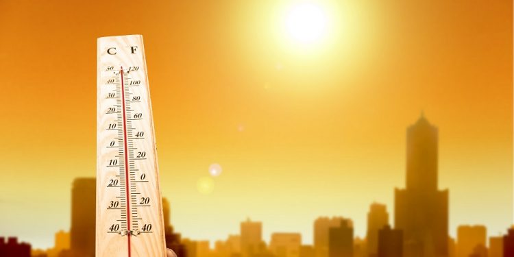 20681099 - heat wave in the city and hand showing thermometer for high temperature